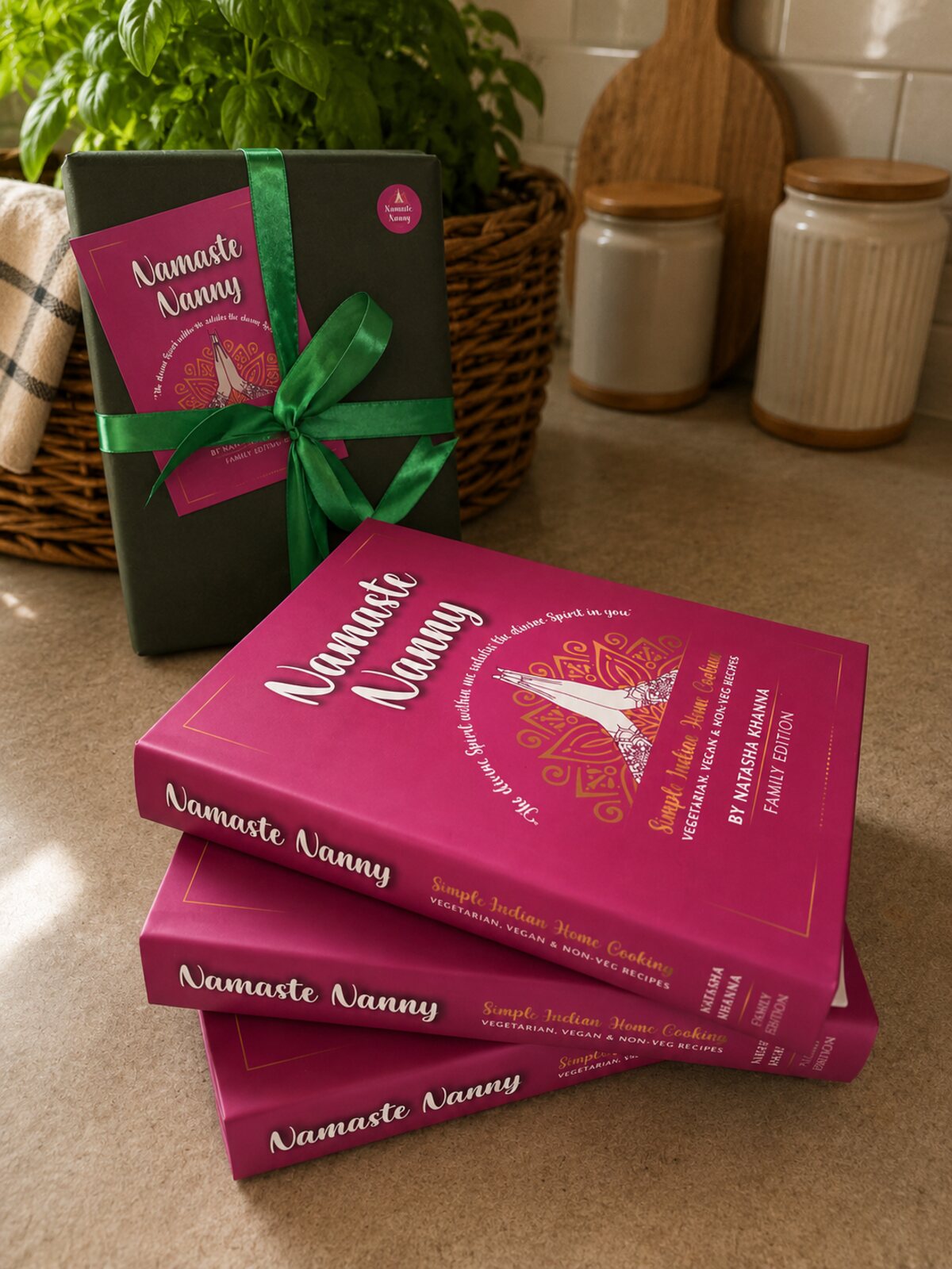 A stack of three Namaste Nanny hardbacks beside a copy gift-wrapped in green paper with emerald ribbon